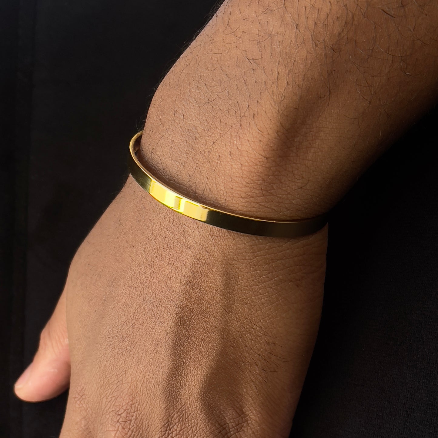Detalhe da pulseira ajustável dourada em forma de C, com acabamento polido em aço inoxidável 316L e estilo sofisticado da The Iron Essence