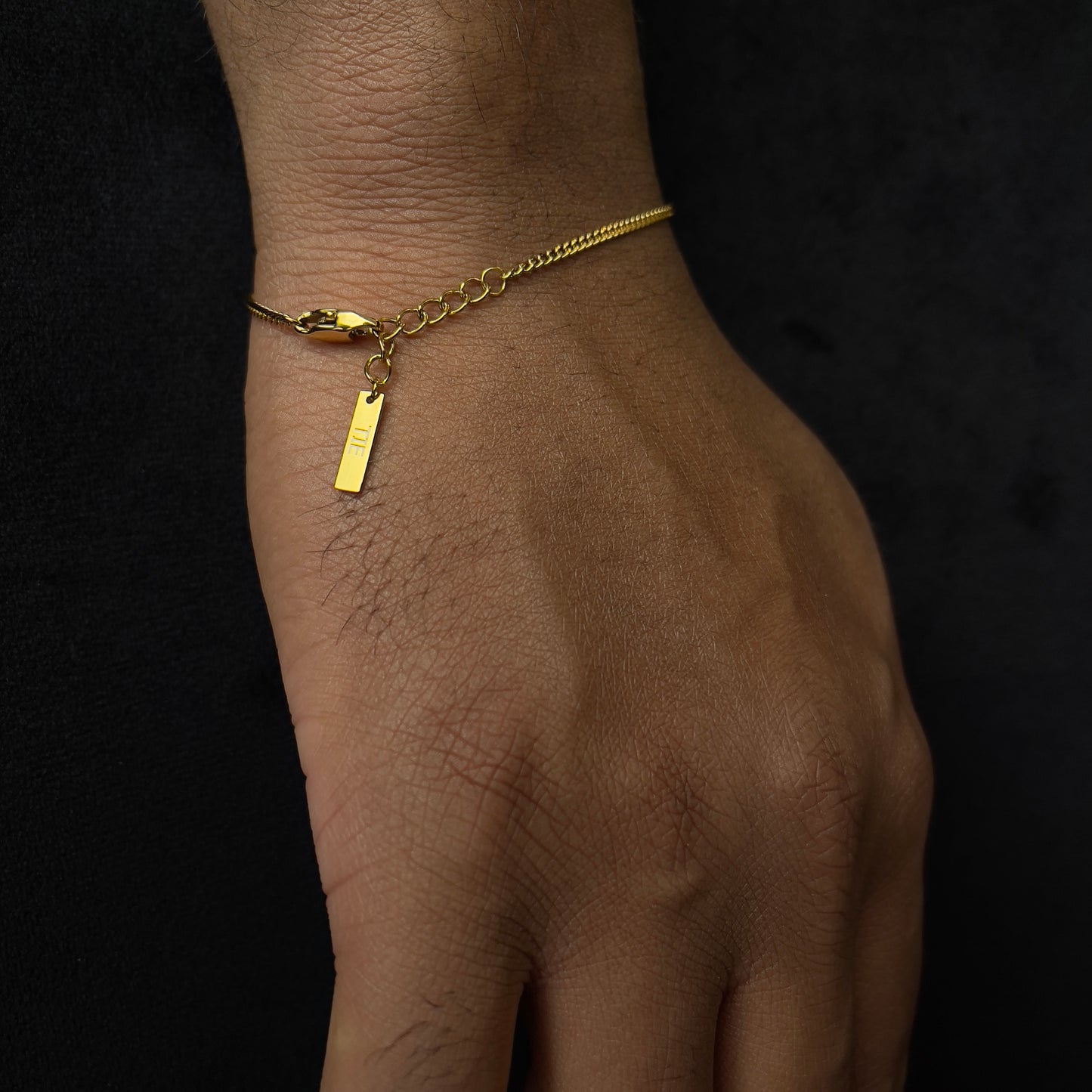 Detalhe da corrente cuban chain dourada minimalista em aço inoxidável 316L, com acabamento polido da The Iron Essence