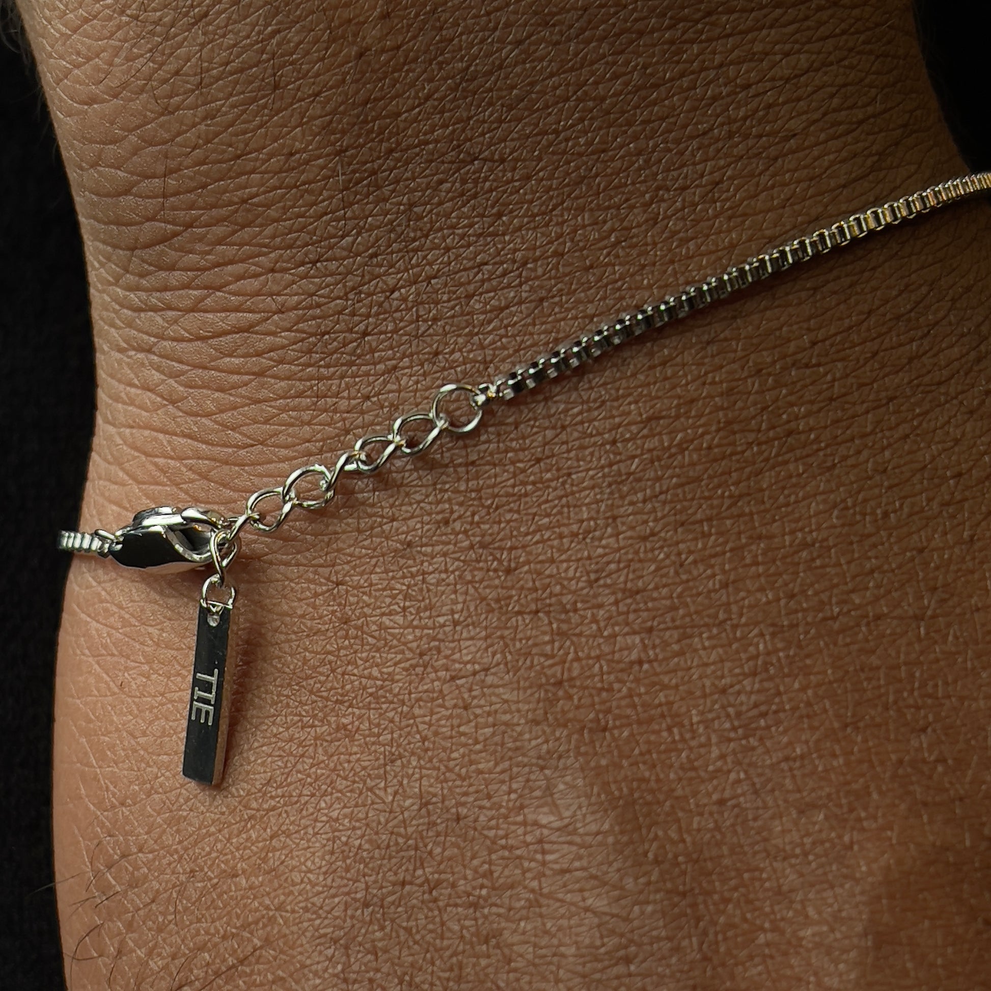 Detalhe dos elos da pulseira box chain prateada em aço inoxidável 316L com acabamento brilhante e robusto