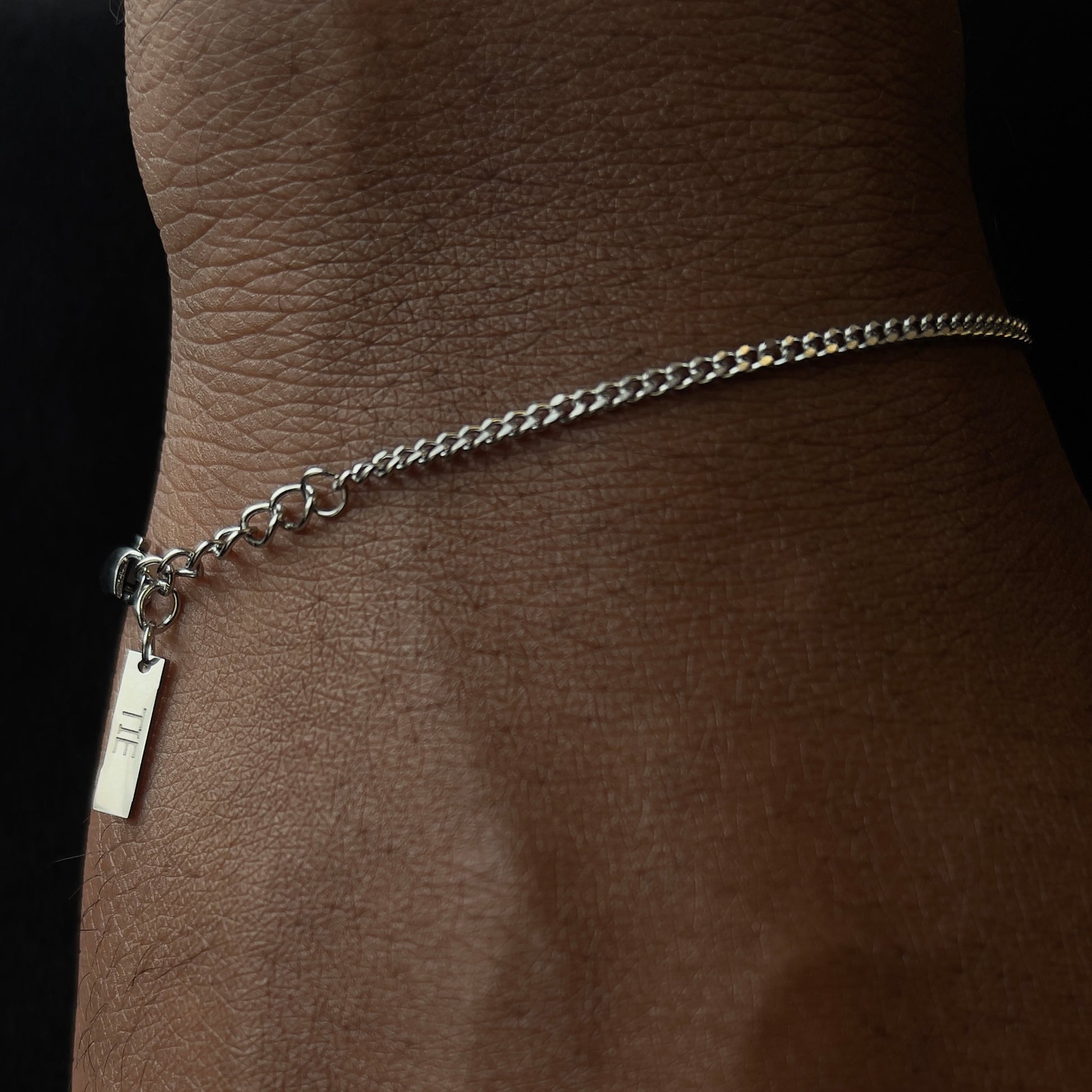 Pulseira cuban chain prateada minimalista em aço inoxidável 316L vista de frente, com design elegante da The Iron Essence